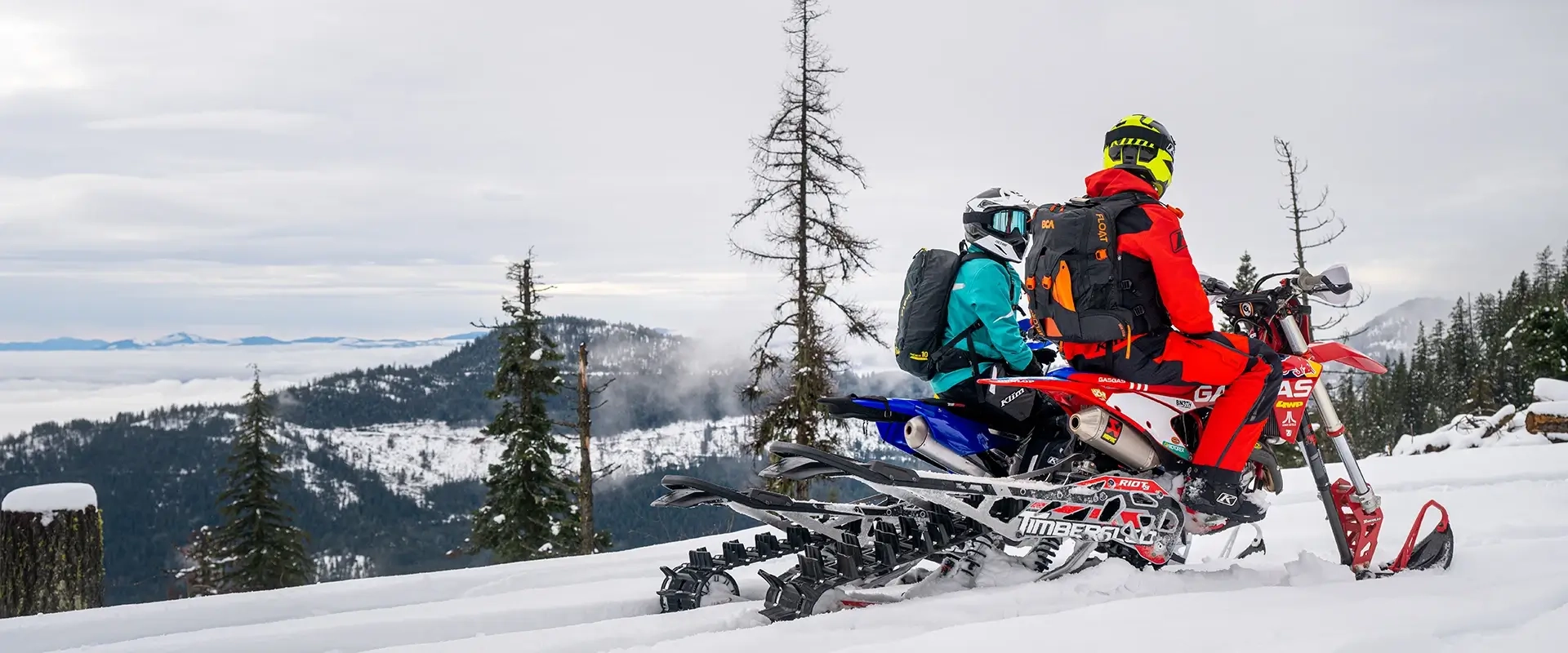 Snow Bikers Riding Through Mountain Terrain in Winter Landscape